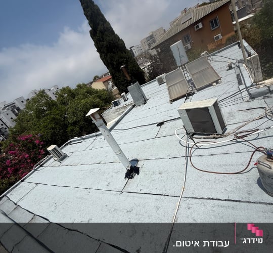 גג עם איטום ושמשיות על רקע שמיים בהירים